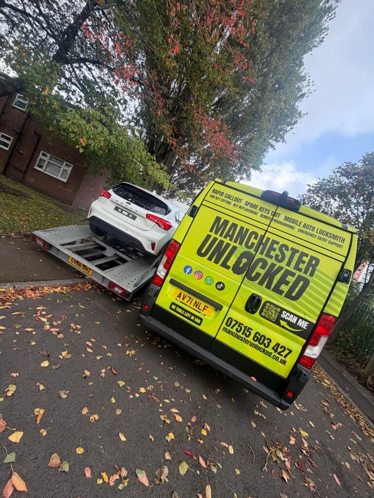 Manchester Unlocked van beside a white Ford Focus on a transporter in Eccles