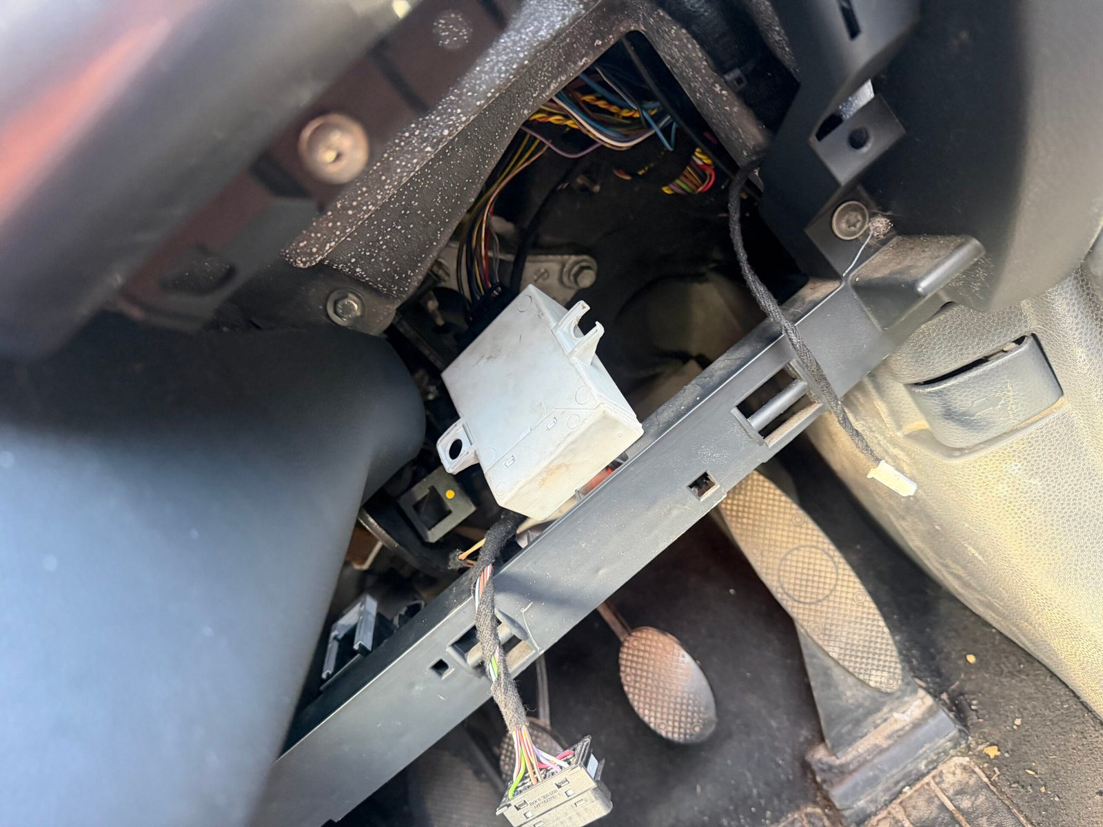 Exposed module and wiring beneath the MINI dashboard during the EWS key job