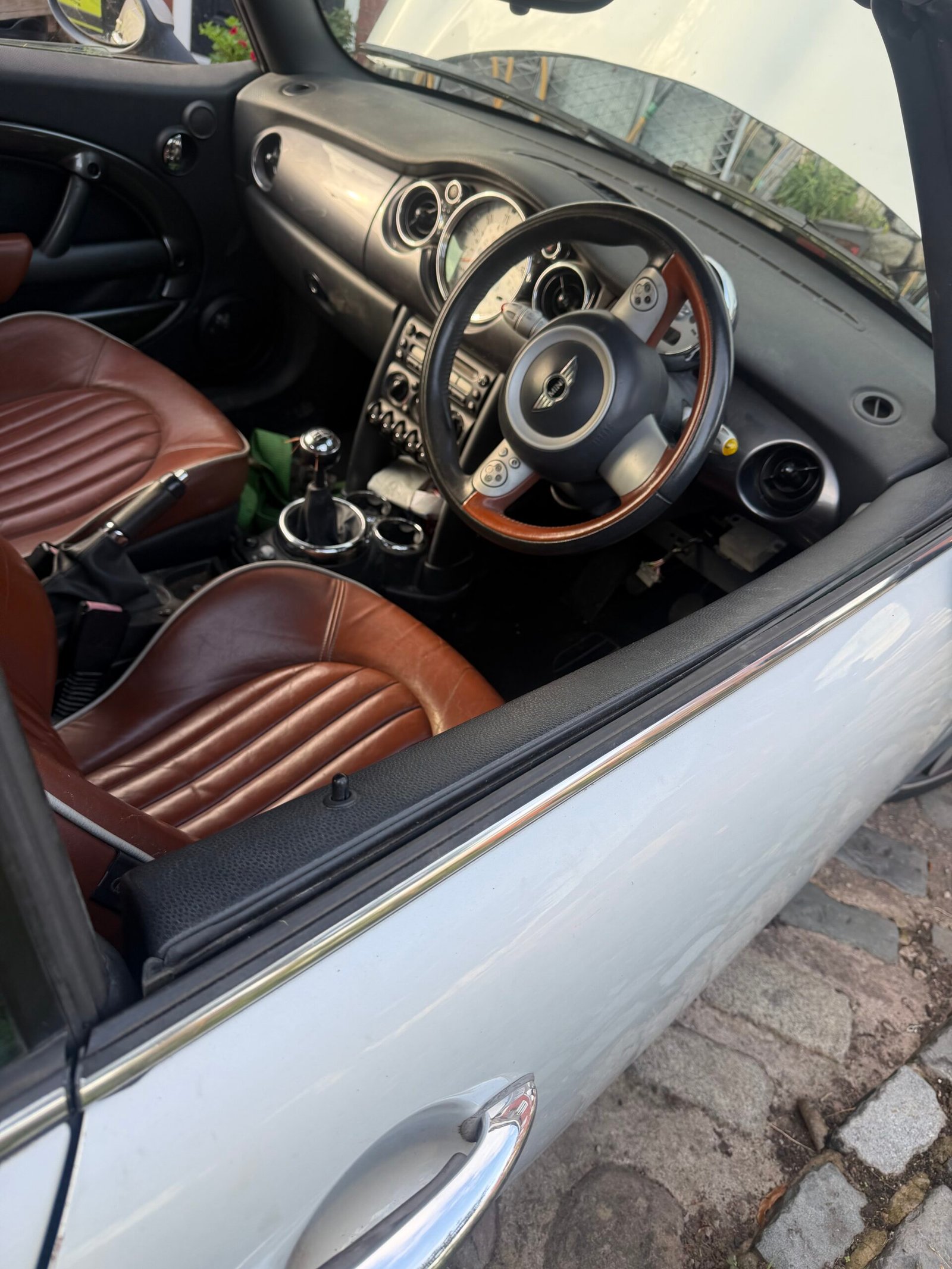 Interior of the 2006 MINI convertible with brown seats and a wood-trimmed steering wheel
