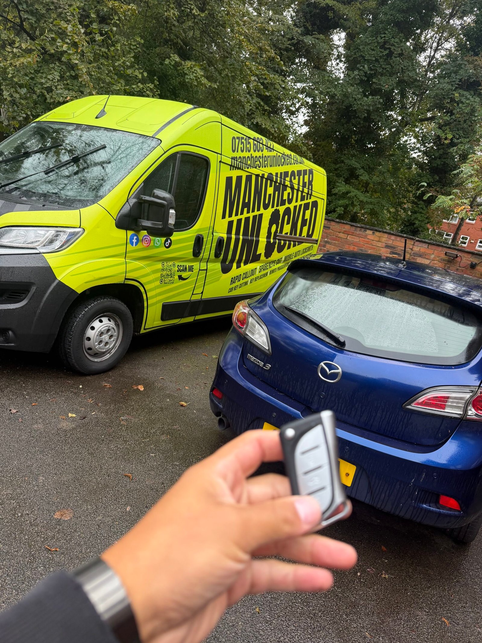 Replacement key held in front of a blue Mazda 3 and the Manchester Unlocked van in Kersal, Salford