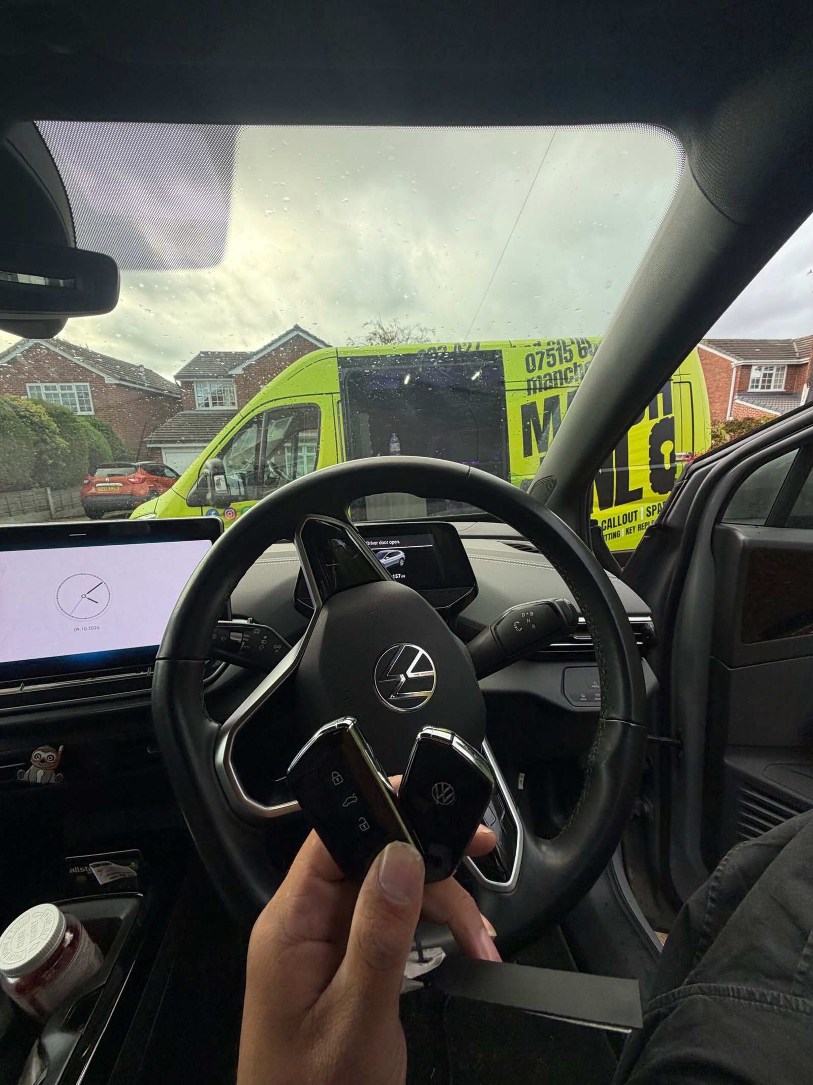 Two Volkswagen keys inside the ID.4 with the Manchester Unlocked locksmith van outside